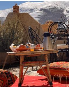 uma mesa com uma chaleira de chá em cima de uma tenda em Chateau Imilchil em Imilchil