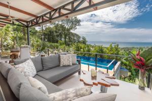 Villa Ananda في Ballena: غرفة معيشة في الهواء الطلق مع أريكة وإطلالة على المحيط