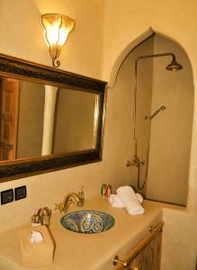 a bathroom with a sink with a mirror and a shower at Chateau Imilchil in Imilchil