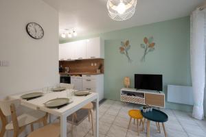 cocina con mesa blanca y sillas en una habitación en Le Pastel - Métro/ Centres de formation-Fac-Thalès en Toulouse