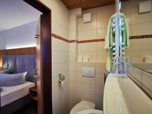 a bathroom with a tub and a toilet and a sink at Hotel Waldmann in Schwangau