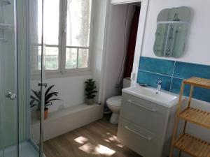 łazienka z umywalką, toaletą i oknem w obiekcie Appartement indépendant dans grande maison w mieście Pouilly-sur-Loire