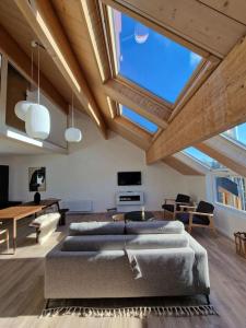 a living room with two couches and a table at Duplex type chalet dans le Jura in Morbier