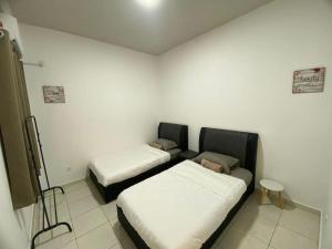 a room with two beds and a tv in it at Sandakan Homestay in Sandakan