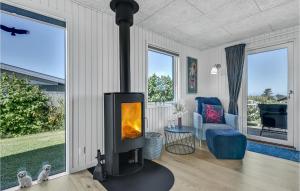 sala de estar con chimenea, sofá y silla en Gorgeous Home In Faaborg With Kitchen, en Bøjden