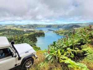 a white truck parked on a hill overlooking a river at Alojamento Santa Cruz in Lagoa