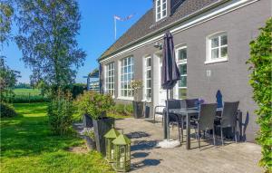 a patio with a table and chairs and an umbrella at Awesome Apartment In Rnne With 1 Bedrooms And Wifi in Rønne