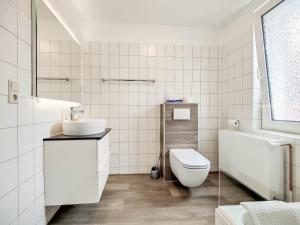 a white bathroom with a toilet and a sink at Haus Menno Janssen - Einzelzimmer in Norderney