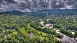 an aerial view of a golf course in the mountains at Killington Center Inn & Suites by Killington VR - 1 Bedrooms in Killington