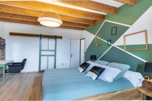 ein Schlafzimmer mit einem großen Bett und einer grünen Wand in der Unterkunft Terre d'Emeraude - Charmante maison avec sauna 
