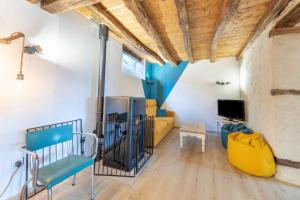 ein Wohnzimmer mit einem gelben Sofa und einem TV in der Unterkunft Terre d'Emeraude - Charmante maison avec sauna 