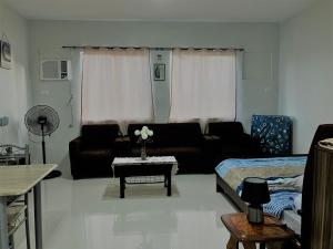a living room with a couch and a table at Camella Homes Bacolod Condo - Ibiza Bldg Unit 5O for rent! with WIFI and Netflix! in Bacolod