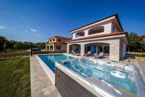 eine Villa mit einem Pool und einem Haus in der Unterkunft Luxury Villa Loma 2 in Sveti Vid-Miholjice