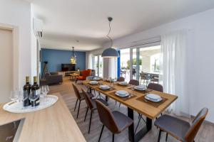 ein Esszimmer und ein Wohnzimmer mit einem Tisch und Stühlen in der Unterkunft Luxury Villa Loma 2 in Sveti Vid-Miholjice