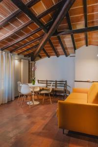 a living room with a yellow couch and a table at Locanda Del Feudo Suite & Restaurant in Castelvetro di Modena