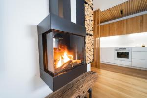 - une cheminée dans le salon dans l'établissement Bor in Bor Luxury Apartment with sauna & garden - Kranjska Gora, à Kranjska Gora
