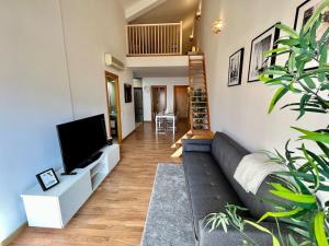 a living room with a couch and a flat screen tv at Apartamento espacioso y familiar in Terrassa