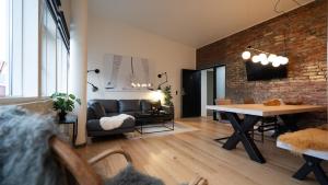 a living room with a table and a brick wall at Broncks Apartment 5 - Modern 2-Bedroom in the Heart of Tórshavn in Tórshavn