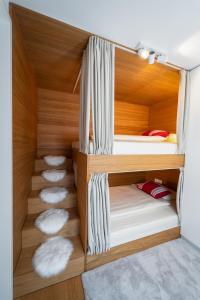 克拉尼斯卡戈拉的住宿－Bor in Bor Luxury Apartment with sauna & garden - Kranjska Gora，客房设有2张双层床和白色枕头。