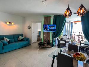 a living room with a blue couch and a table at DREAMY SUNSET, SeaFront, Direct Access To The Promenade,Wifi,Free Parking in Los Cristianos