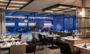 un restaurant avec des tables et des chaises ainsi qu'une salle à manger dans l'établissement Hotel Schmung, à Alpe di Siusi