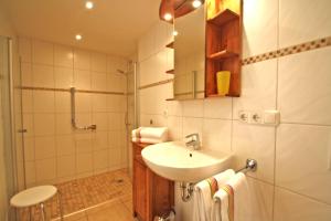 ein weißes Bad mit einem Waschbecken und einer Dusche in der Unterkunft Ferienwohnungen Bergerhof in Sachrang