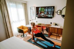 a woman doing yoga in a hotel room at Hard Rock Hotel Madrid in Madrid