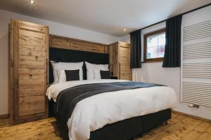 a bedroom with a large bed with a wooden headboard at VAYA Seefeld in Seefeld in Tirol