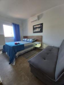 een slaapkamer met een bed en een bank bij Sobrado novo in Florianópolis