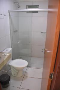 La salle de bains est pourvue de toilettes et d'une douche en verre. dans l'établissement Hotel Center Vitoria, à Vitória de Santo Antão