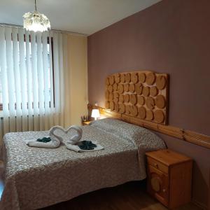 a bedroom with a bed with two hearts on it at Guest House Planinski Zdravets in Bansko