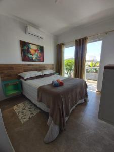 1 dormitorio con cama y ventana grande en Sobrado novo, en Florianópolis
