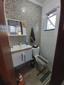 a bathroom with a sink and a toilet and a mirror at Sobrado novo in Florianópolis