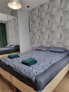 a bedroom with a bed with two green towels on it at Słoneczny apartament w centrum miasta Osiedle Słoneczne Radom in Radom