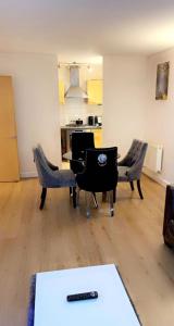 a living room with chairs and a table with a remote at Solonzo apartment in North Woolwich