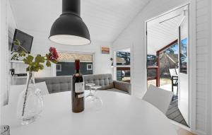 uma sala de jantar branca com uma garrafa de vinho na mesa em Gorgeous Home In Nex With Wifi em Neksø