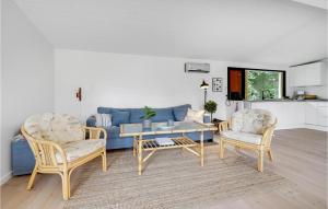 Bøtø ByにあるGorgeous Home In Væggerløse With 4 Bedrooms And Wifiのリビングルーム(青いソファ、椅子2脚付)