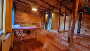 a room with a table in a wooden house at Harmonie Tree house Cotagges Chalet Predeal Trei Brazi in Predeal