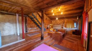 una sala de estar con una escalera en una cabaña de madera en Harmonie Tree house Cotagges Chalet Predeal Trei Brazi en Predeal