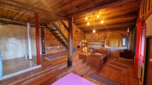 a living room with a staircase in a log cabin at Harmonie Tree house Cotagges Chalet Predeal Trei Brazi in Predeal