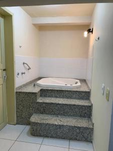 uma banheira numa casa de banho com escadas em Apartamento itapirubá em Imbituba