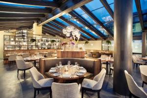 een restaurant met tafels en stoelen en een glazen plafond bij Hotel UTO KULM car-free hideaway in Zurich in Zürich