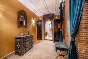 Cette chambre comprend une coiffeuse, un miroir et des rideaux bleus. dans l'établissement Maïpa Boutique Riad, à Marrakech