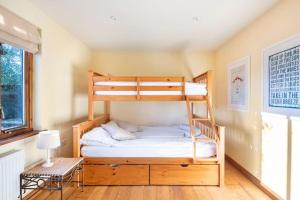 a bedroom with a bunk bed with a ladder at Priory Farm Barn in Eye