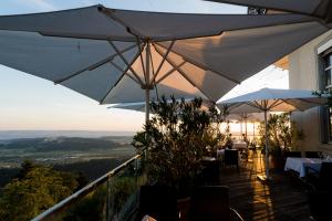 ein Restaurant mit Tischen und Sonnenschirmen auf einem Balkon in der Unterkunft Hotel UTO KULM car-free hideaway in Zurich in Zürich