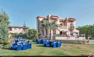 Villa elzaher في Qaryat Shākūsh: مجموعة من الكراسي الزرقاء أمام المنزل