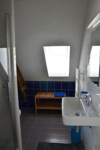 La salle de bains est pourvue d'un lavabo et de carrelage bleu. dans l'établissement Le Tertre de la Nouette, 