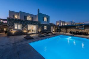 a large swimming pool in front of a house at Tohu Villas Mykonos in Ornos