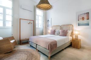 een slaapkamer met een bed, een stoel en ramen bij Ocean Porto - Beach House in Matosinhos