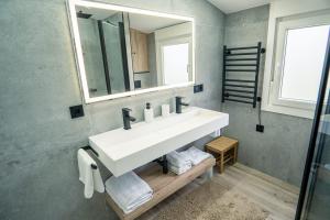 a bathroom with a white sink and a mirror at APARTAMENTO PEDRADOURO in Malpica +3 photos